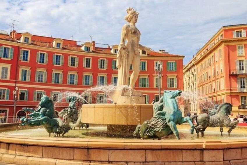 Una fontana con statue e cavalli, circondata da edifici. 3