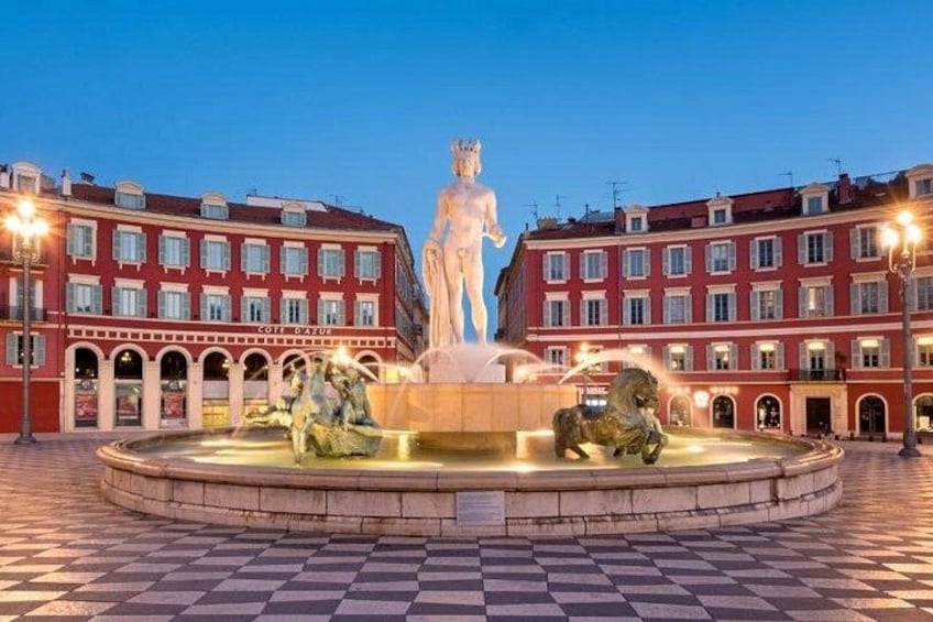Una fontana con statue in una piazza circondata da edifici rossi. 5