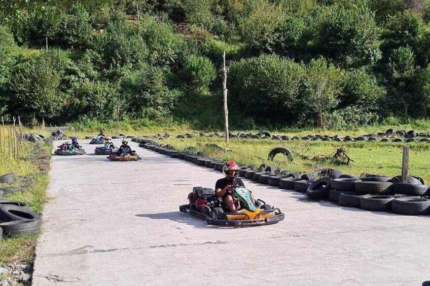 Go-karts on a paved track surrounded by greenery. 2