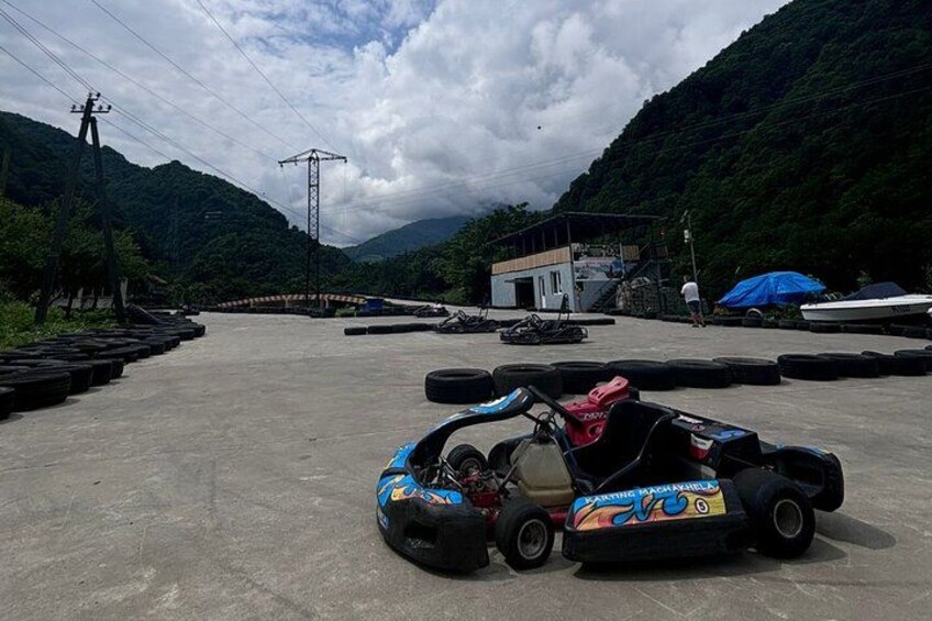 Eine Go-Kart-Bahn mit einem Go-Kart, Reifen und einem Gebäude im Hintergrund. 2