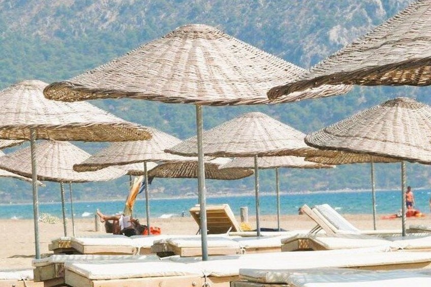 Beach umbrellas, lounge chairs, and a person sunbathing. 3