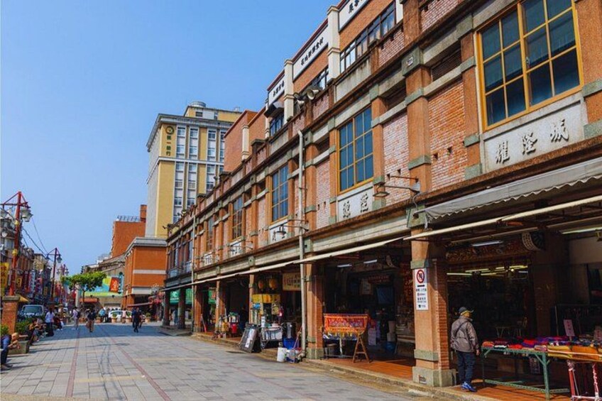 A street with brick buildings, a market stall, and a sign with Chinese characters. 3