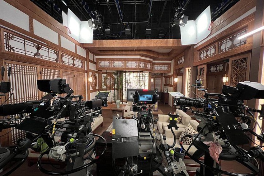A film set with cameras, lighting equipment, and a traditional interior design. 5