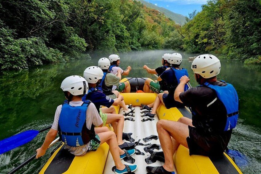 Un grupo de personas haciendo rafting en un río rodeado de exuberante vegetación. 2