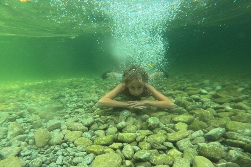 Une personne sous l’eau, entourée de rochers et d’eau. 5