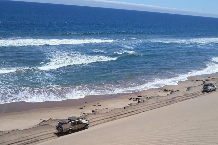 Une plage avec un véhicule sur le sable et l’océan en arrière-plan. 3