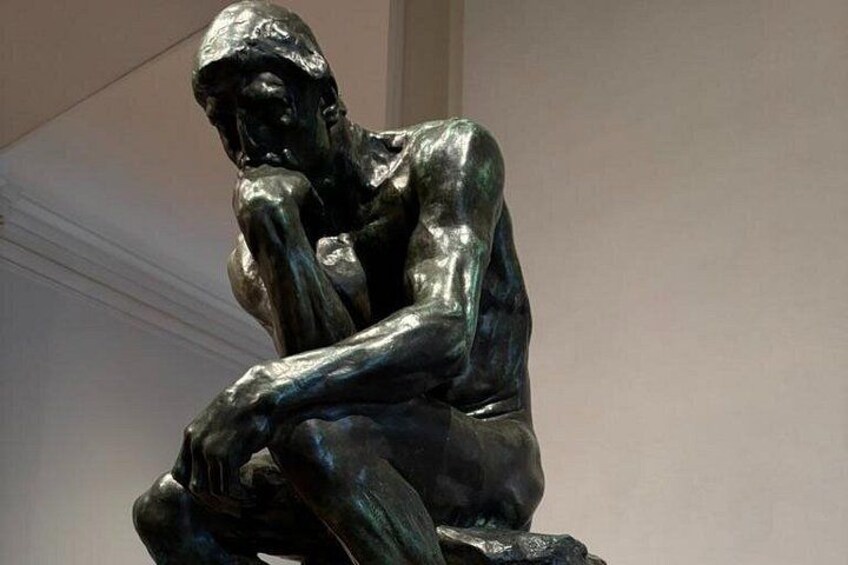 Eine bronzene Skulptur eines sitzenden Mannes, der seinen Kopf in die Hand legt. 2