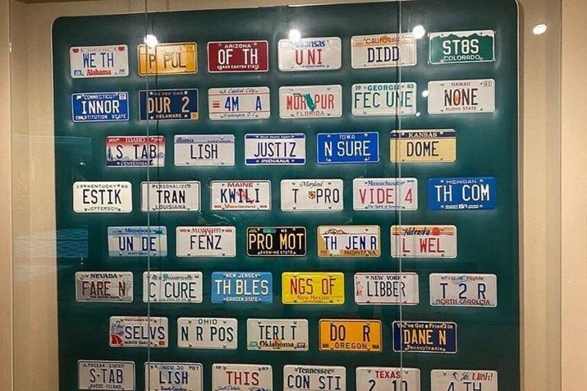 Eine Sammlung verschiedener Nummernschilder an einer Wand. 4