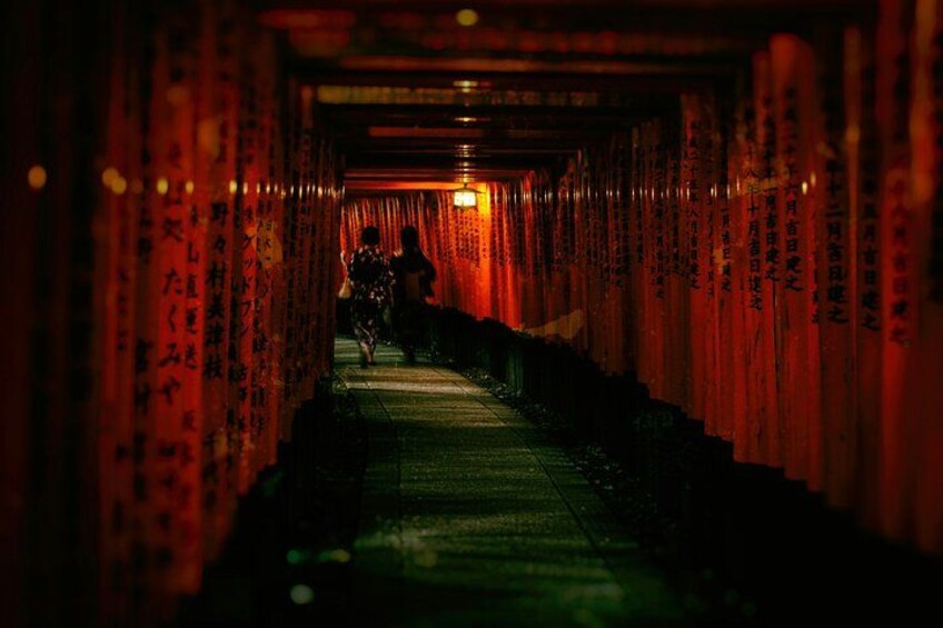A corridor with red torii gates and Japanese characters. 3