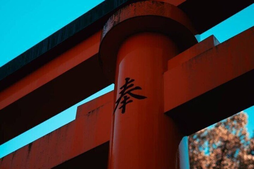 A red torii gate with Japanese characters. 2