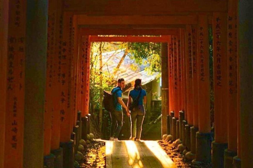 A pathway flanked by traditional Japanese torii gates leading to a covered area. 4