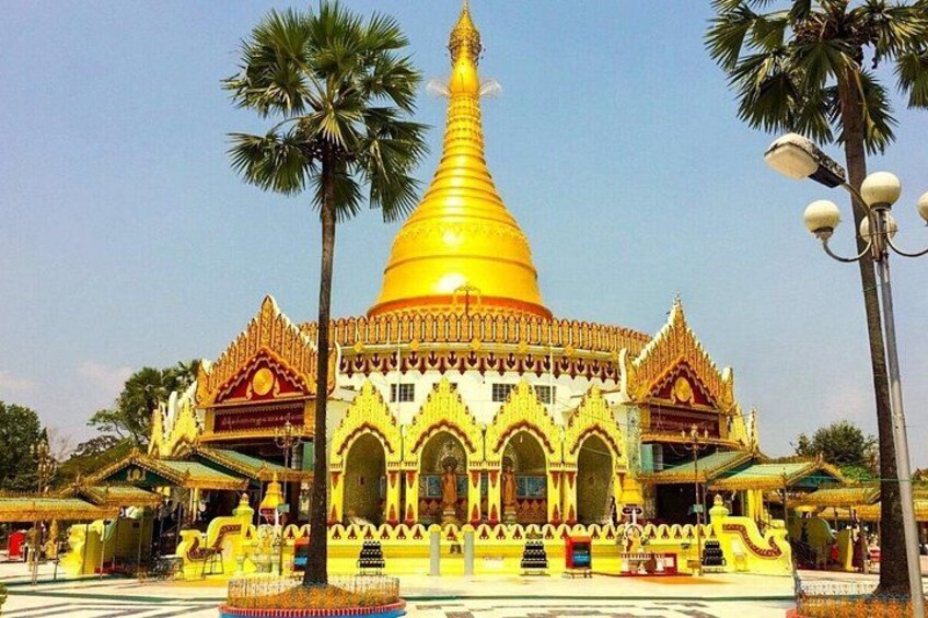 A golden stupa with intricate architecture, palm trees, and a clear sky. 4