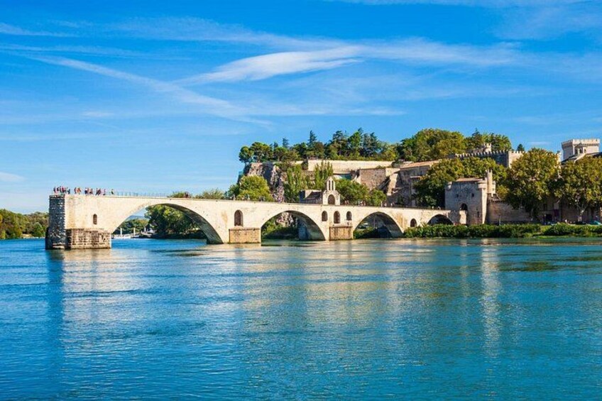 Un pont de pierre enjambe une rivière, et de l’autre côté, sur la rive opposée, se trouve une ville. 1