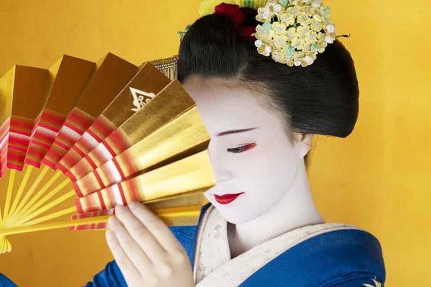 A person in traditional Japanese attire holding a fan. 1