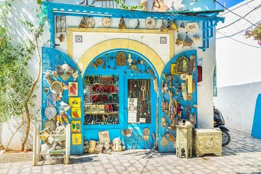 A blue and white shop with various items displayed outside. 2