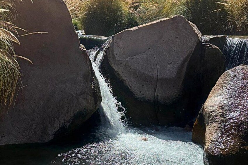 Een waterval stort neer over rotsen in een natuurlijke omgeving. 2