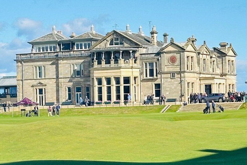 A large historic building with a well-maintained lawn in front. 1