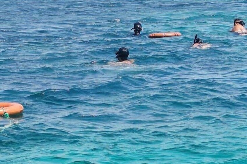 People swimming in the ocean with lifebuoys. 2
