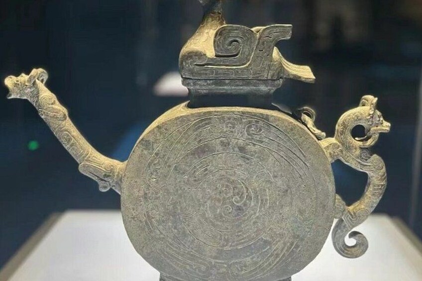 Ein antikes Brongefäß mit aufwendigen Verzierungen und einer Drachenfigur am Henkel. 5