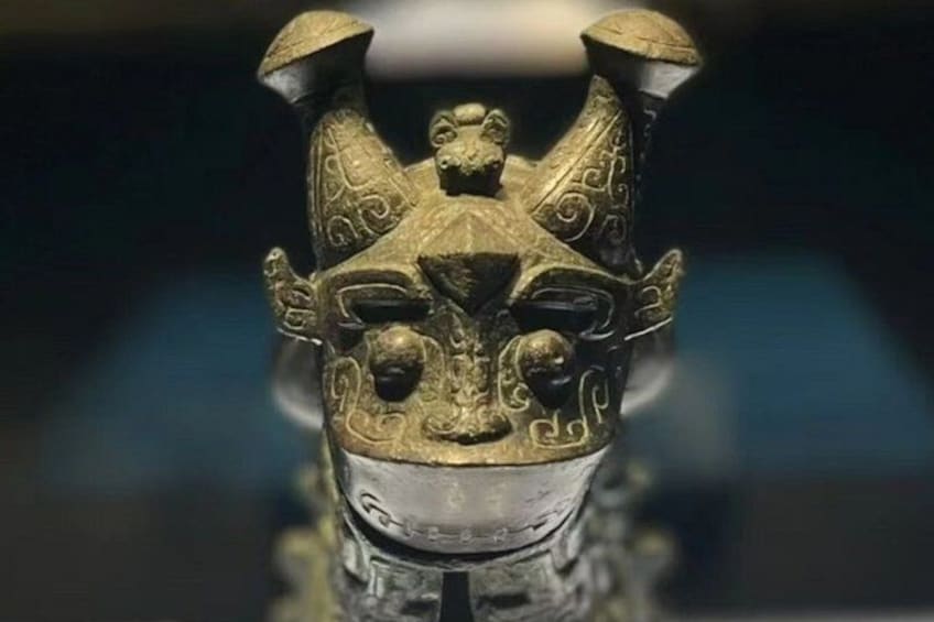 Eine bronzene Statue mit aufwendigen Verzierungen und einem markanten Kopfschmuck. 4
