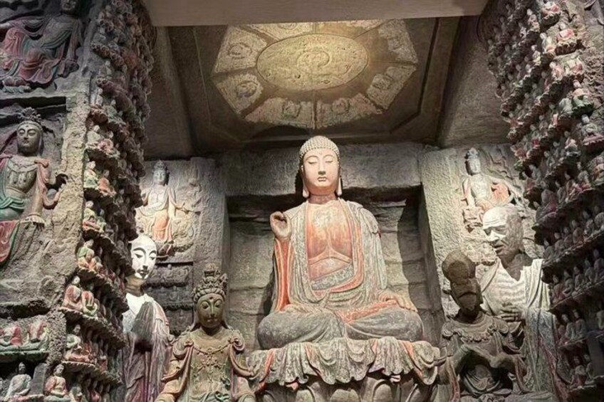 A large seated Buddha statue surrounded by smaller statues and intricate carvings. 2