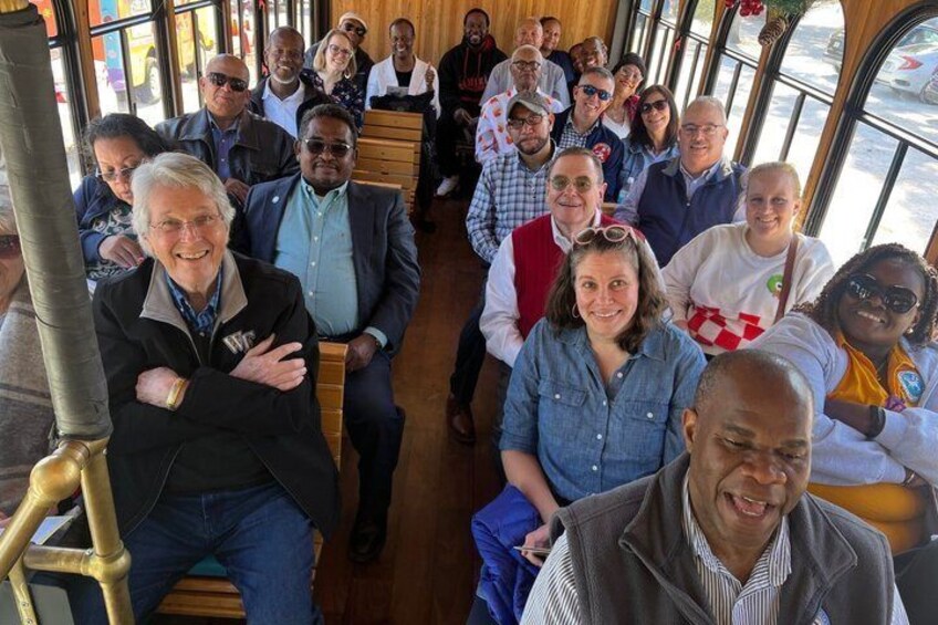 Een groep mensen zit in een bus. 2