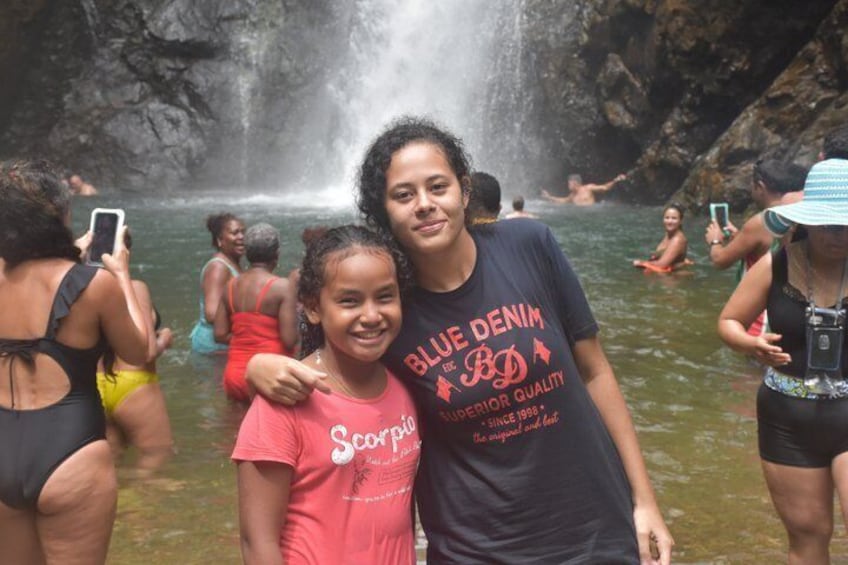 A waterfall with people in the water and a person in a blue denim shirt. 3