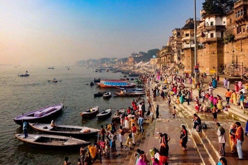 A crowded riverside with boats and people. 3
