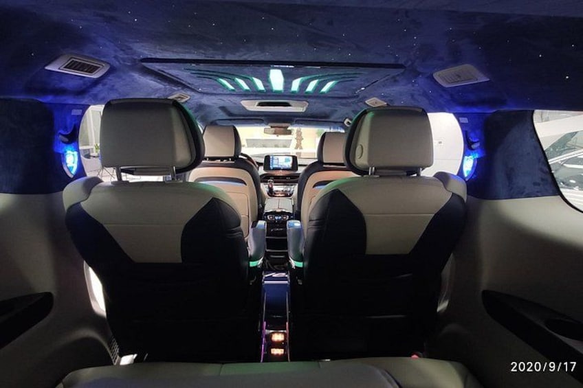 A vehicle interior with two seats, a central console, and ambient lighting. 3