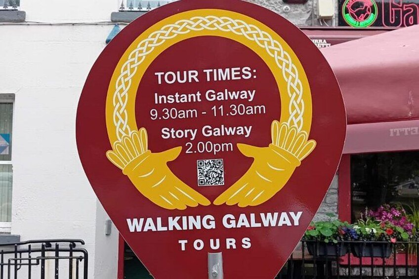 En rund skylt med information om tidpunkterna för guidade stadsvandringar i Galway. 2
