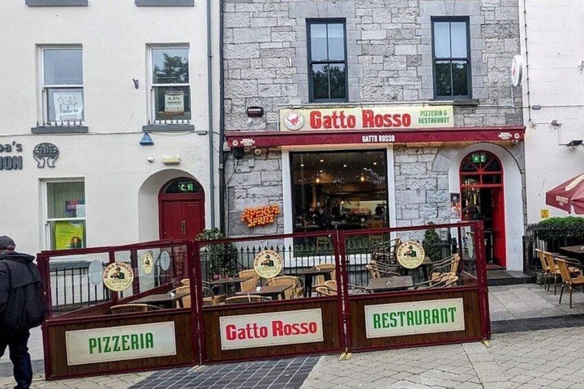 En restaurang som heter Gatto Rosso, med uteservering och en skylt som visar att det är en pizzeria. 4