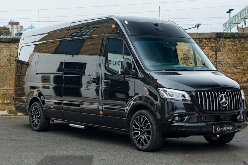 A black Mercedes-Benz Sprinter van parked on a paved surface. 2