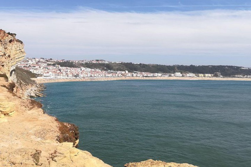 A coastal city with a prominent cliff and a calm sea. 3