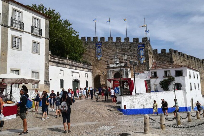 A historic fort with tourists, cobblestone streets, and traditional buildings. 4
