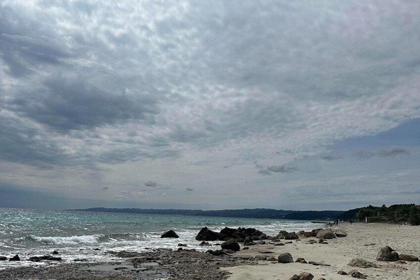A beach with rocks and a cloudy sky. 2