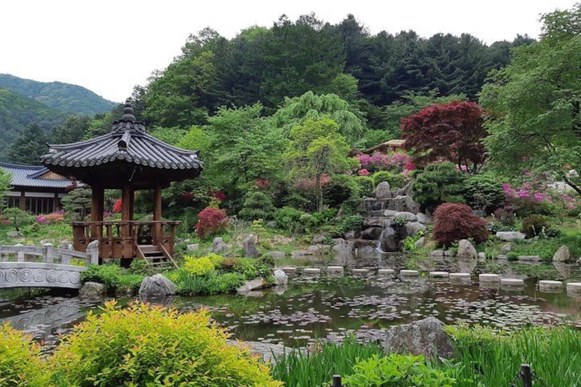 A traditional Japanese garden with a gazebo, koi pond, and lush greenery. 2