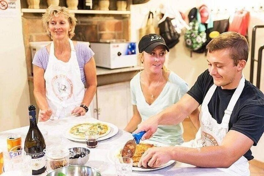 Tre personer ved et bord med mad, en flaske og en skål. 2
