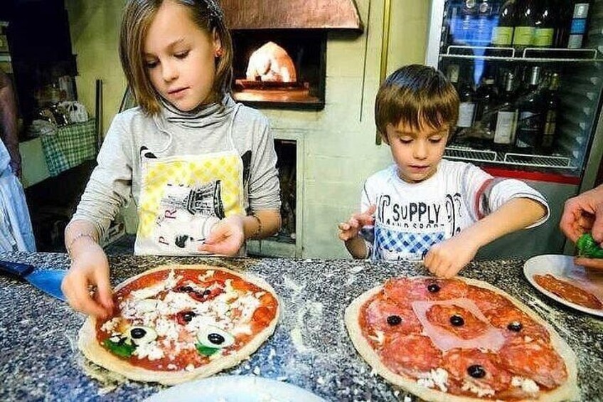 To børn laver pizza på en køkkenbordplade. 4