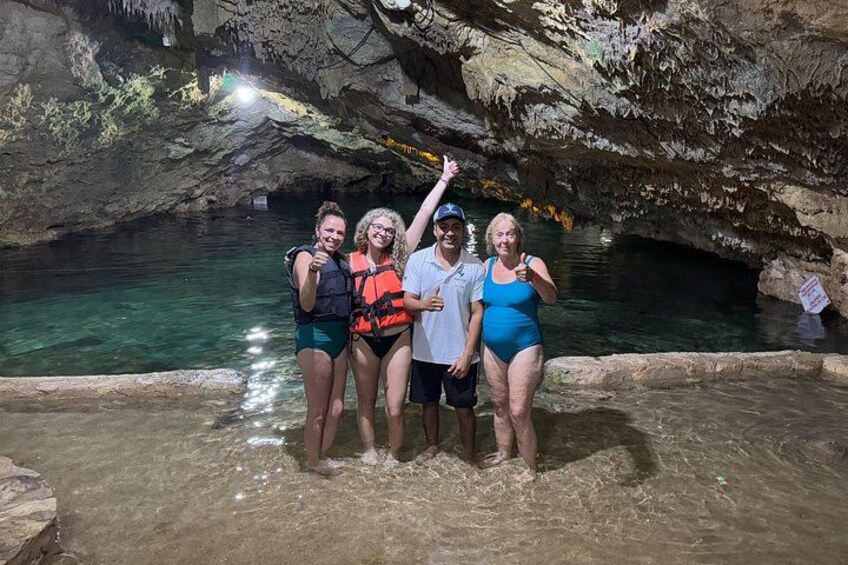 En grupp människor i en grotta med en liten sjö eller vattenpöl. 5