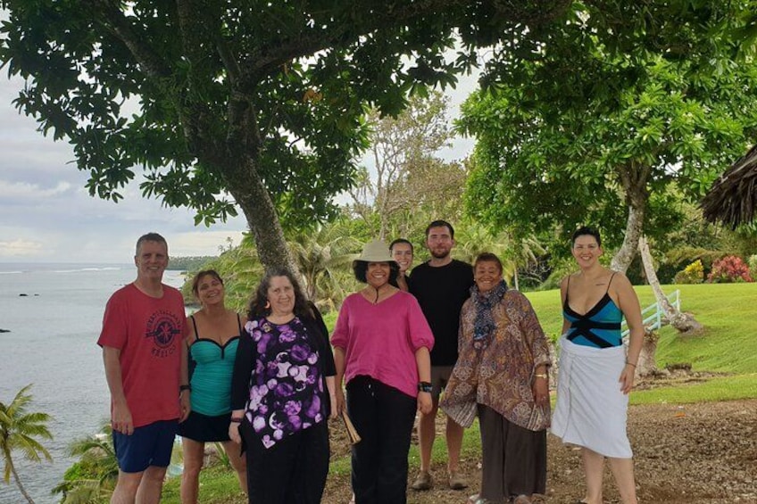 Un groupe de personnes se tient sous un arbre, près d’une étendue d’eau. 5