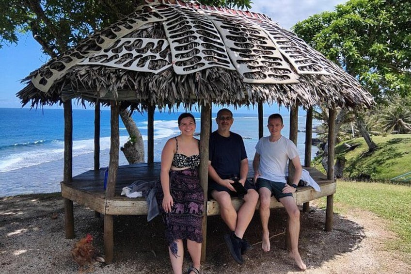Ein Pavillon mit einem Reetdach, ein Strand und das Meer im Hintergrund. 3