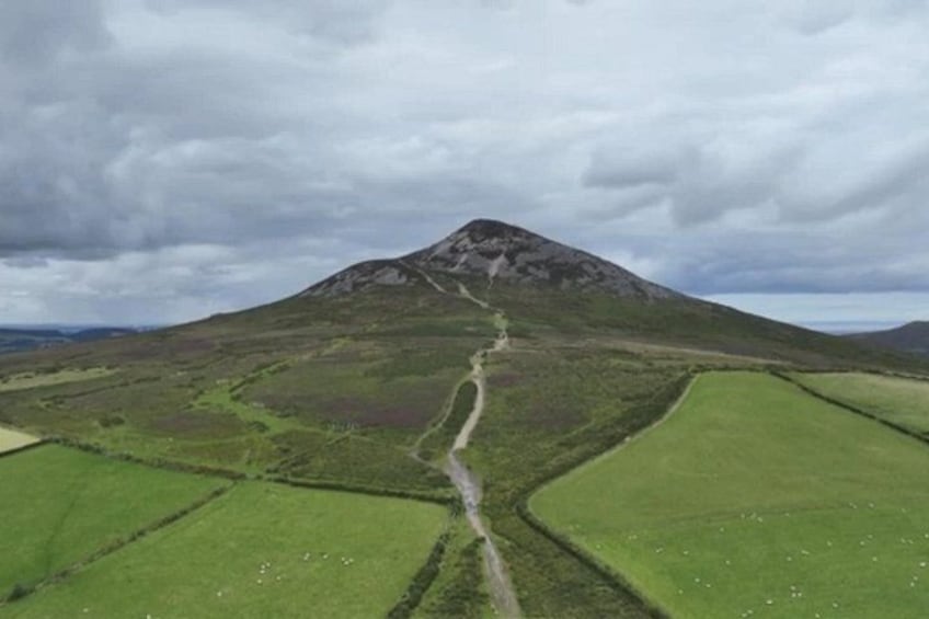 A mountain with a winding path leading to its peak. 2