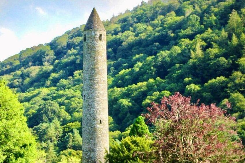 A tall stone tower surrounded by lush green forest. 5
