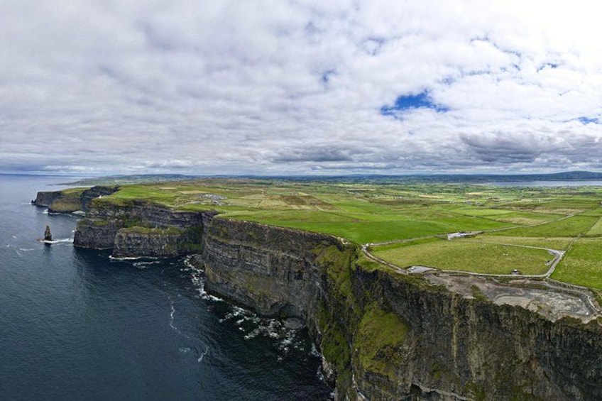 Eine Küstenlandschaft mit Klippen, Blick auf das Meer und ferne Hügel. 4