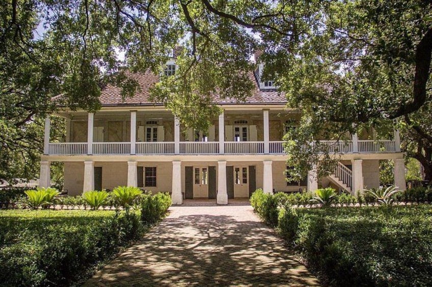 Un bâtiment de style colonial doté d’une cour intérieure, entouré de haies et d’arbres soigneusement entretenus. 2