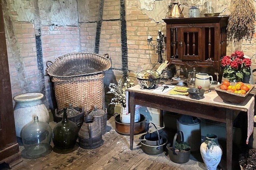 A rustic kitchen with wooden barrels, a woven basket, and a wooden cabinet. 5