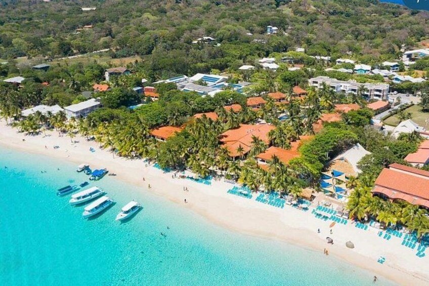 Ein Küstenresort mit Strand, Booten und Palmen. 2