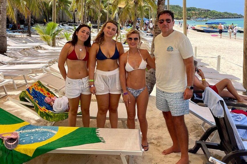 Ein Strand mit Liegestühlen, einer brasilianischen Flagge und Palmen. 3