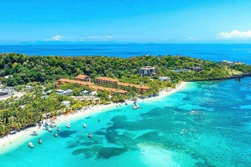 Un paisaje costero con playa, barcos y edificios. 2