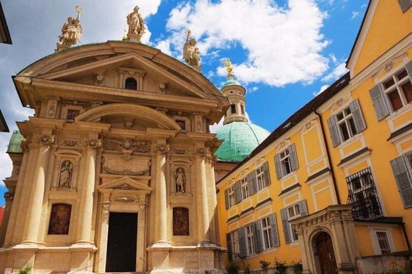 Un edificio classico con architettura elaborata, una cupola verde e edifici gialli adiacenti. 2